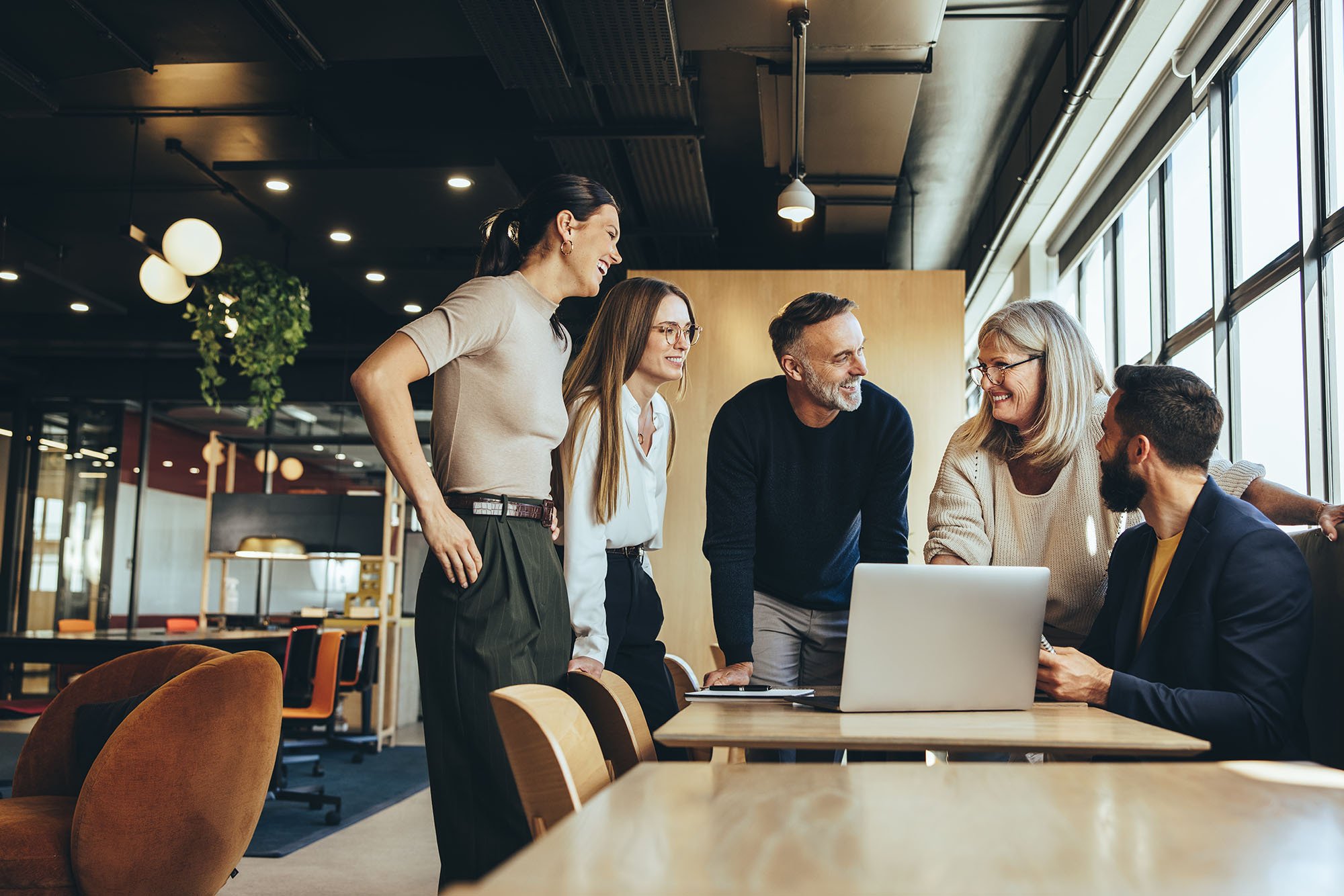 Team around laptop smiling Team around laptop smiling